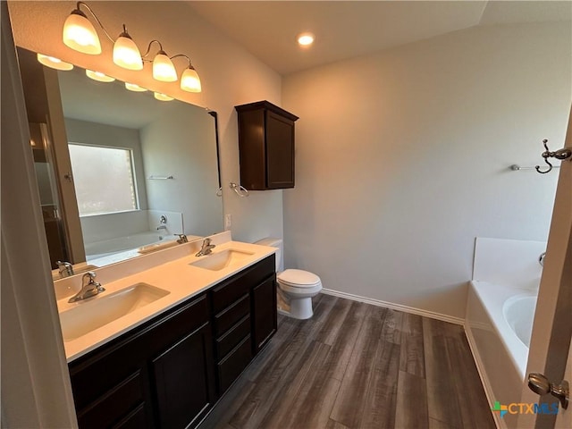 bathroom with vanity, hardwood / wood-style flooring, toilet, and a bathing tub