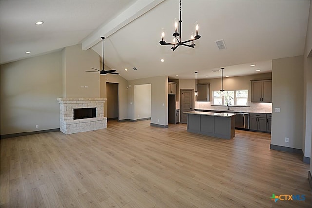 kitchen featuring gray cabinets, hanging light fixtures, a center island, stainless steel dishwasher, and light hardwood / wood-style floors