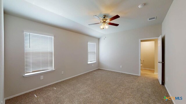 spare room featuring light colored carpet and ceiling fan