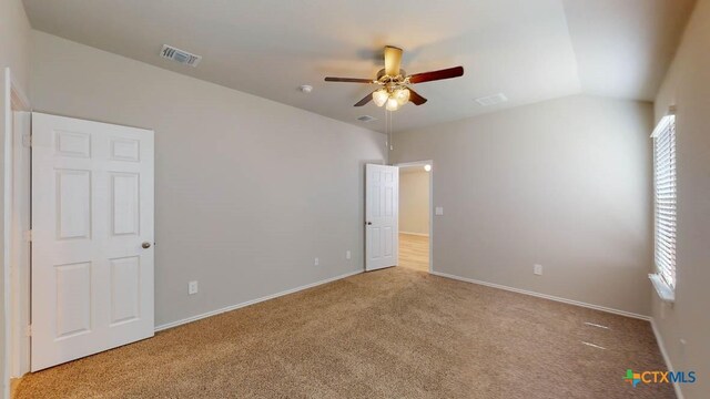 unfurnished bedroom featuring ceiling fan, light carpet, and vaulted ceiling