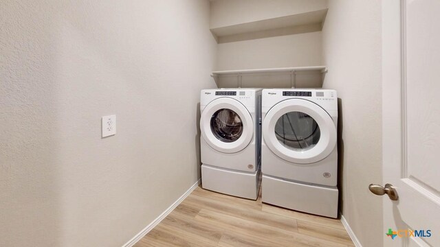 washroom with separate washer and dryer and light hardwood / wood-style flooring