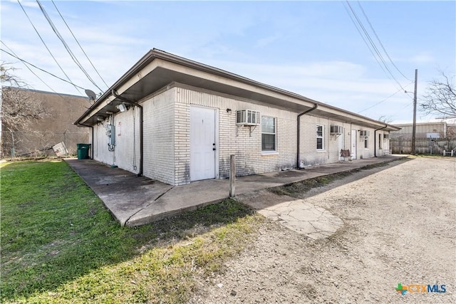 rear view of property featuring a yard, a wall unit AC, and a patio