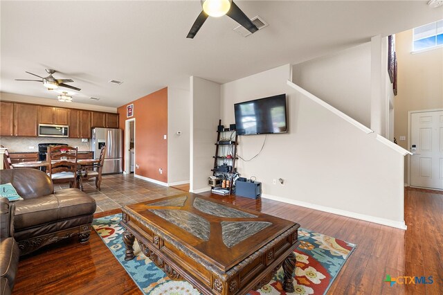 326 Comal Run, Hutto, TX 78634 - living room featuring ceiling fan, stairs, and dark wood finished floors