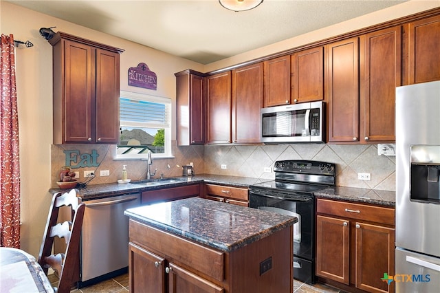 326 Comal Run, Hutto, TX 78634 - kitchen with appliances with stainless steel finishes, backsplash, dark stone counters, and a kitchen island