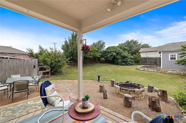 326 Comal Run, Hutto, TX 78634 - fenced backyard featuring a fire pit, outdoor dining area, a patio area, and an outbuilding