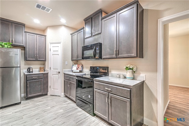 kitchen with dark brown cabinets, light hardwood / wood-style flooring, and black appliances