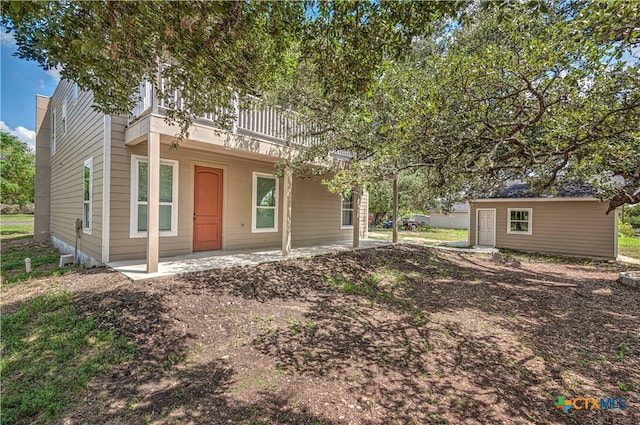 view of front of home featuring a patio area and an outbuilding