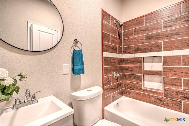 full bathroom featuring toilet, tiled shower / bath combo, and sink