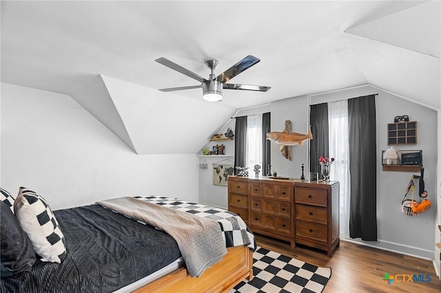 bedroom with ceiling fan, lofted ceiling, and dark hardwood / wood-style flooring