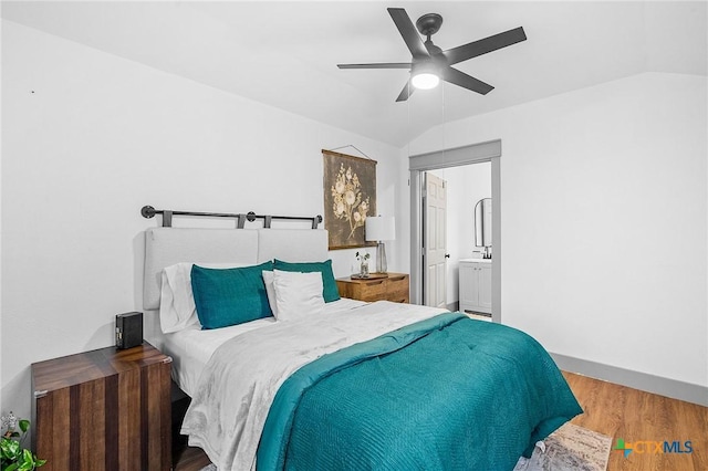 bedroom with ceiling fan, ensuite bathroom, vaulted ceiling, and hardwood / wood-style floors