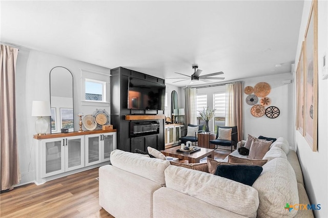 living room featuring light hardwood / wood-style floors and ceiling fan