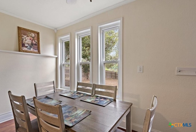 dining area with dark hardwood / wood-style flooring and crown molding