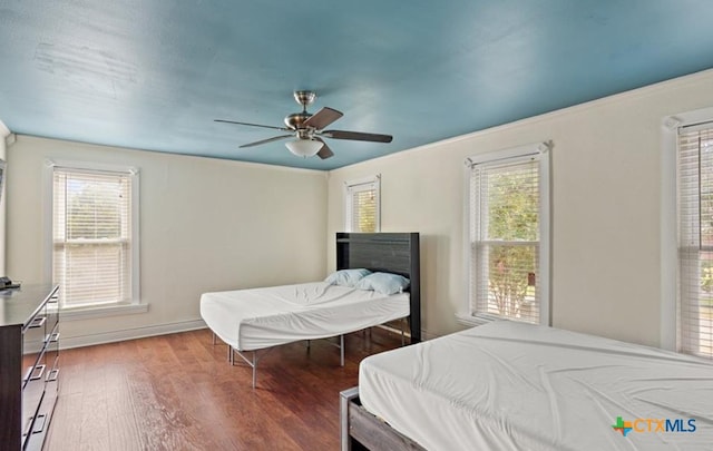 bedroom with hardwood / wood-style floors, multiple windows, and ceiling fan