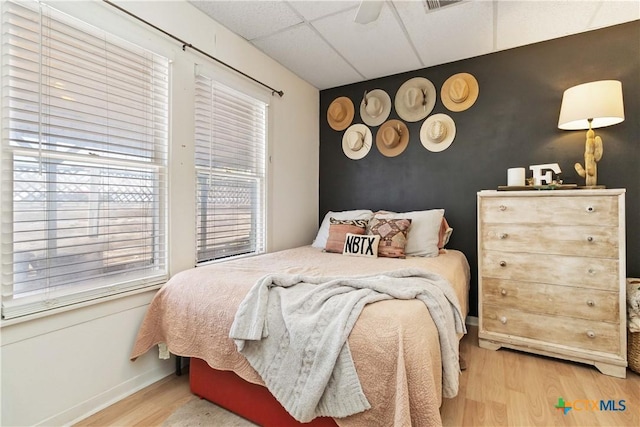 859 Pine St, New Braunfels, TX 78130 - bedroom featuring an accent wall, wood finished floors, a paneled ceiling, baseboards, and a ceiling fan