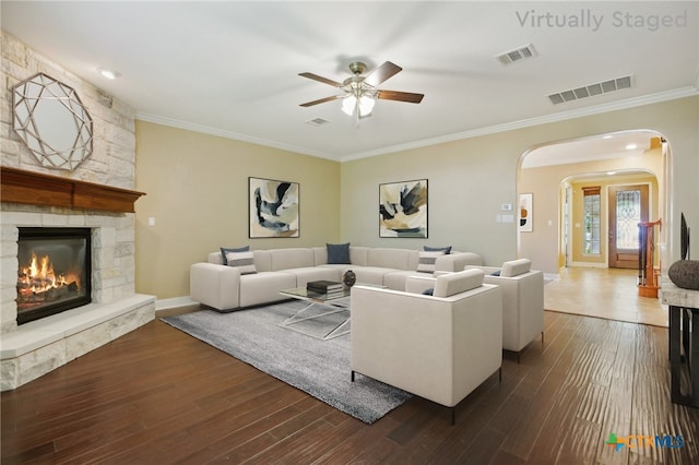12109 Bryony Dr, Austin, TX 78739 - living area with arched walkways, ornamental molding, a ceiling fan, a fireplace, and dark wood finished floors