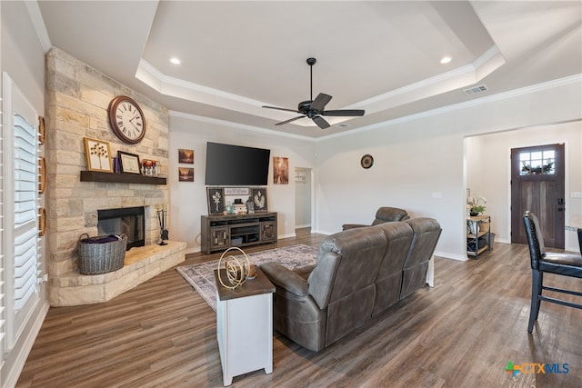 living room featuring ornamental molding, dark hardwood / wood-style flooring, ceiling fan, and a tray ceiling