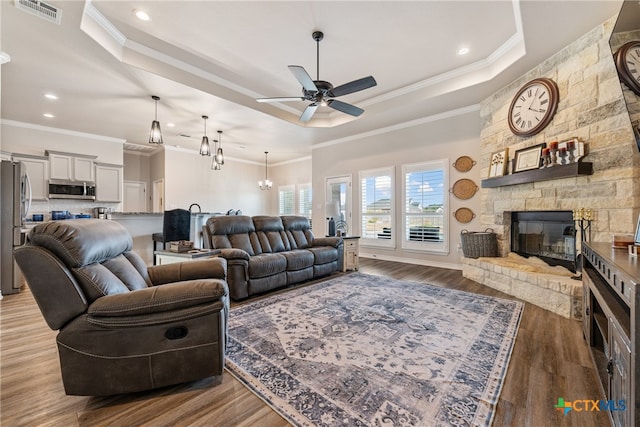 living room featuring a fireplace, ornamental molding, and light hardwood / wood-style flooring