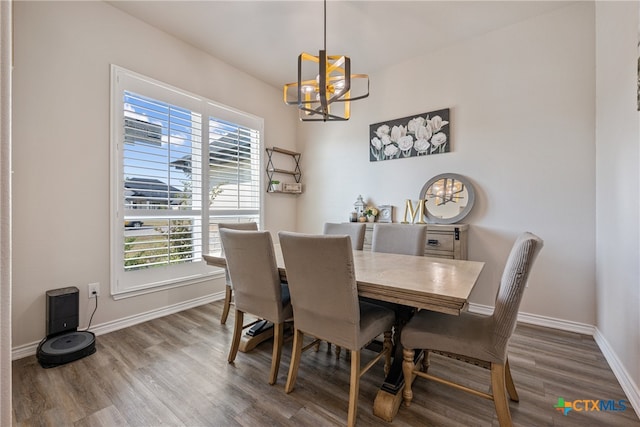 dining area featuring wood-type flooring and a notable chandelier