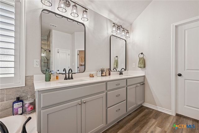 bathroom featuring lofted ceiling, vanity, and hardwood / wood-style flooring