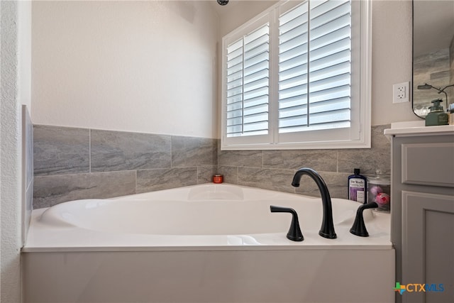 bathroom with vanity and a tub