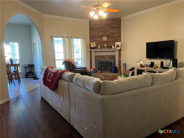 2019 Stonehenge Dr, Harker Heights, TX 76548 - living area featuring a ceiling fan, arched walkways, a fireplace, crown molding, and plenty of natural light