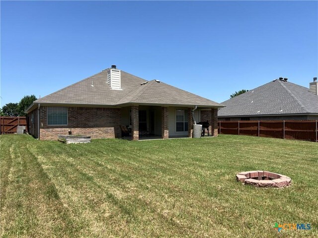2019 Stonehenge Dr, Harker Heights, TX 76548 - back of property with a fire pit, a chimney, brick siding, and a shingled roof