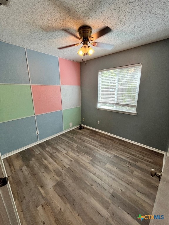 unfurnished room featuring ceiling fan, hardwood / wood-style floors, and a textured ceiling