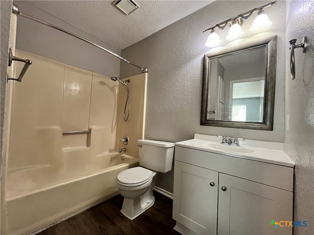 full bathroom featuring washtub / shower combination, a textured ceiling, toilet, vanity, and hardwood / wood-style flooring