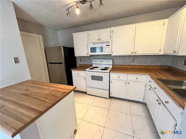 kitchen featuring butcher block counters, white cabinetry, tasteful backsplash, a textured ceiling, and white appliances