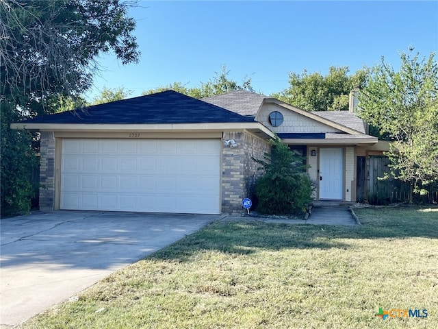 ranch-style house with a garage and a front lawn