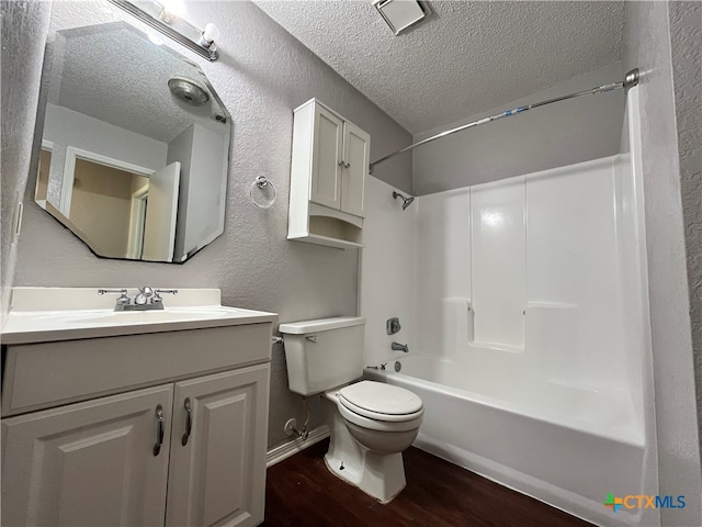 full bathroom featuring vanity, hardwood / wood-style flooring, toilet, a textured ceiling, and shower / bath combination