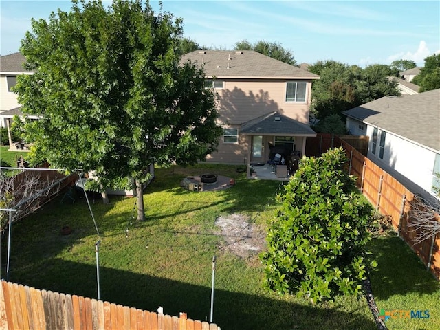 back of property featuring a yard, a patio area, and a fire pit