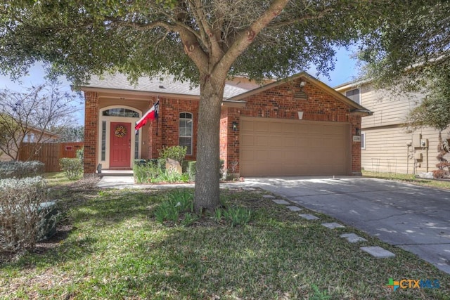 ranch-style home with a garage, concrete driveway, brick siding, and fence