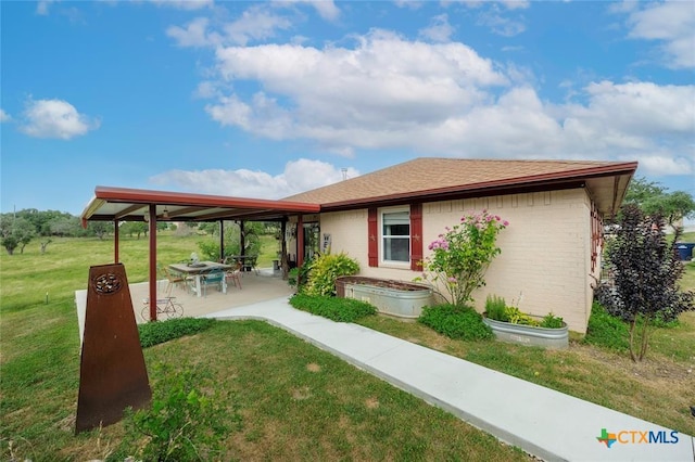 exterior space with a patio, a yard, a gazebo, and brick siding