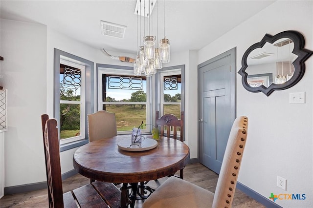 dining room with visible vents, baseboards, and wood finished floors