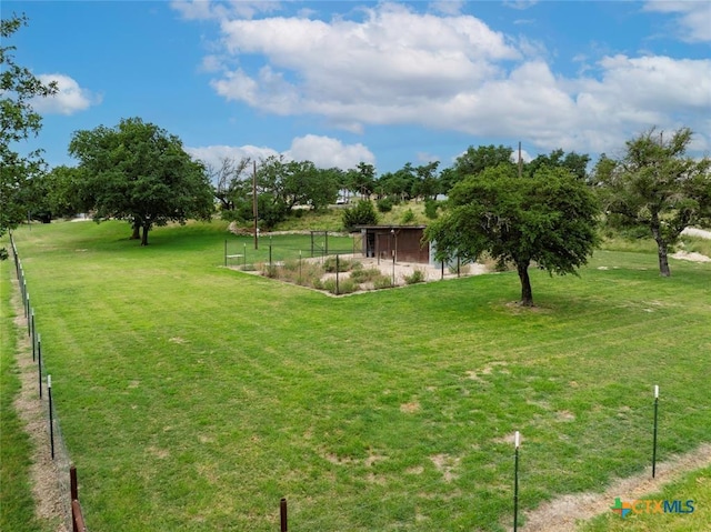 view of yard featuring an outdoor structure and fence