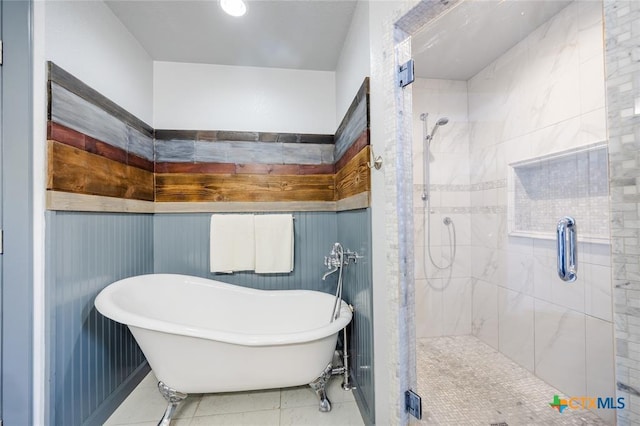 full bathroom with a freestanding tub, a shower stall, and tile patterned floors