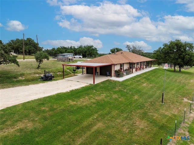 view of front facade featuring driveway, a carport, and a front yard