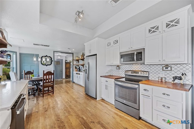 kitchen with open shelves, tasteful backsplash, visible vents, appliances with stainless steel finishes, and wood counters