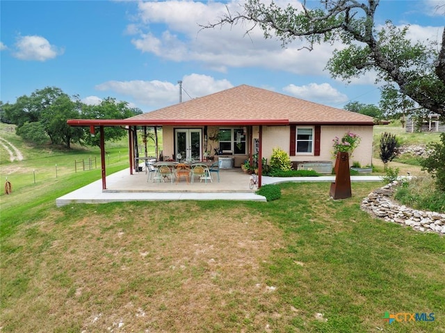 rear view of house featuring a yard, a patio, french doors, and fence