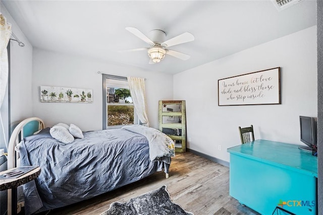 bedroom featuring ceiling fan, wood finished floors, visible vents, and baseboards