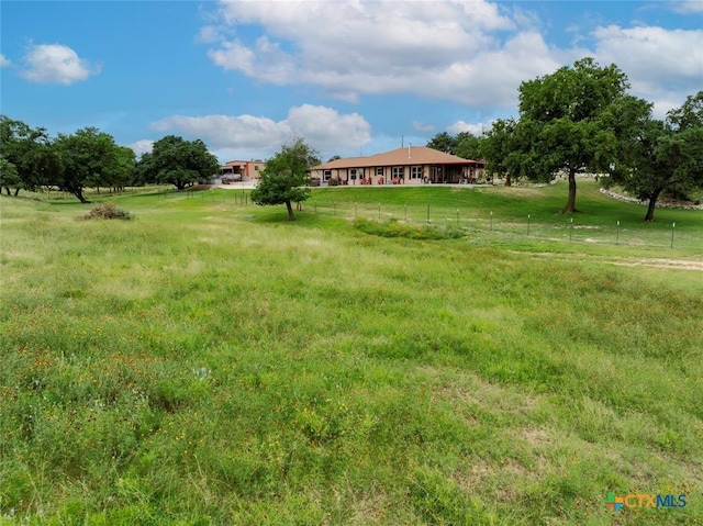 view of yard featuring a rural view and fence