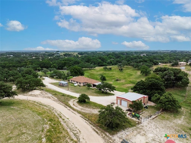 bird's eye view with a wooded view