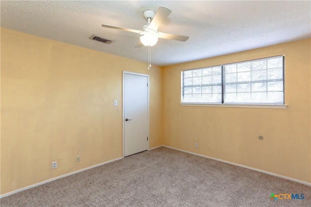 unfurnished room featuring ceiling fan, a textured ceiling, light carpet, visible vents, and baseboards