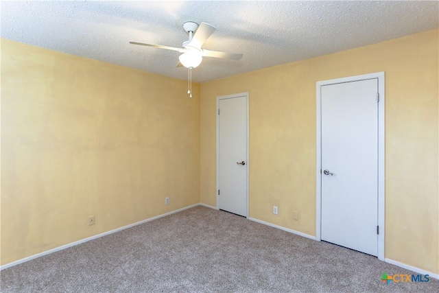 unfurnished bedroom featuring light carpet, a ceiling fan, baseboards, and a textured ceiling