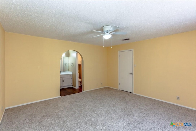 2505 Canyon Creek Dr, Temple, TX 76502 - unfurnished room with arched walkways, a ceiling fan, dark carpet, and baseboards