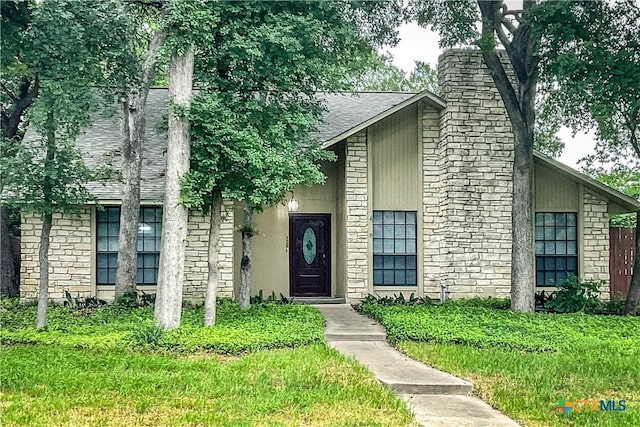 2505 Canyon Creek Dr, Temple, TX 76502 - view of front facade with a shingled roof, a chimney, and stone siding