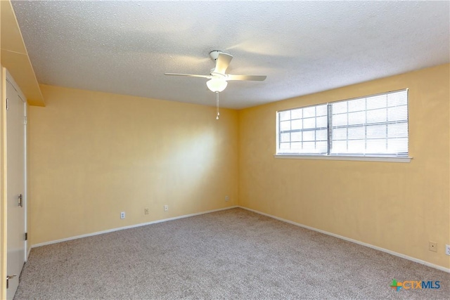 spare room with ceiling fan, baseboards, a textured ceiling, and light colored carpet