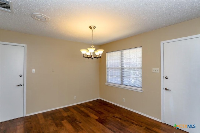 interior space featuring an inviting chandelier, a textured ceiling, visible vents, and dark wood-style flooring