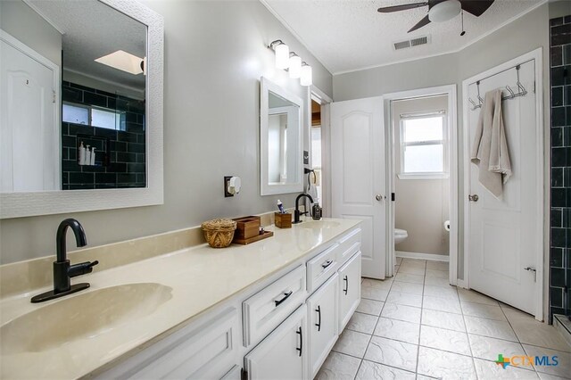 209 Brookway Dr, Killeen, TX 76542 - bathroom with a ceiling fan, double vanity, a textured ceiling, marble look tiles, and a tile shower